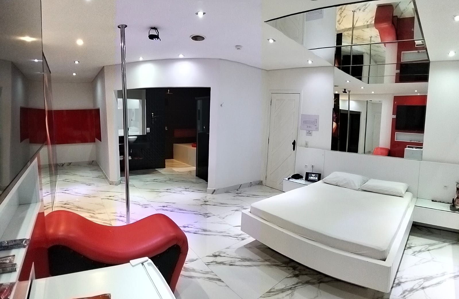 Suíte premium do Motel Libidus com iluminação cinematográfica